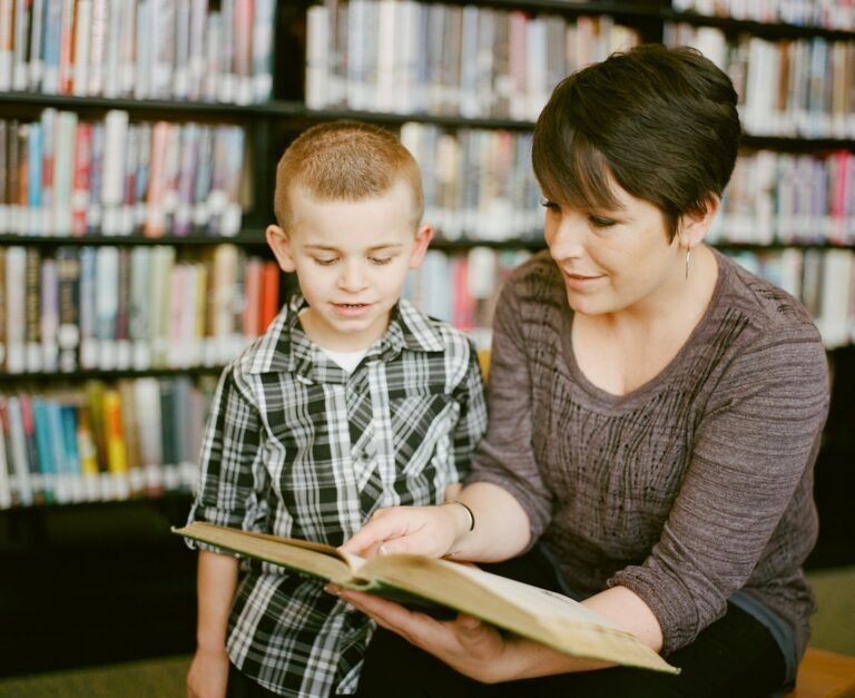 boy in gray sweater beside boy in gray and white plaid dress shirt