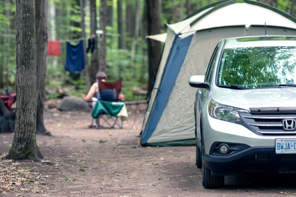 person sitting on camping chair near dome tent