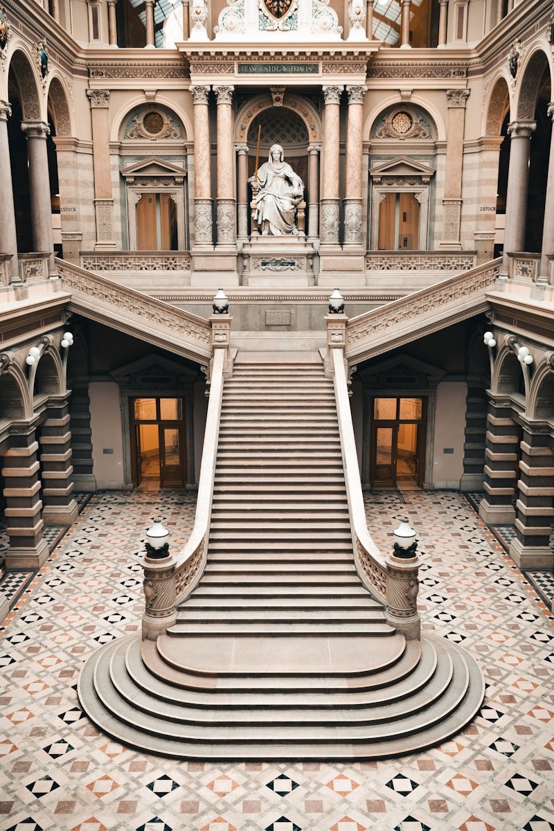 a large staircase in a building with a clock on the wall