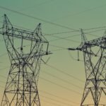 black transmission towers under green sky