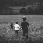 three boys running on field