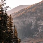 a group of people standing on the shore of a lake