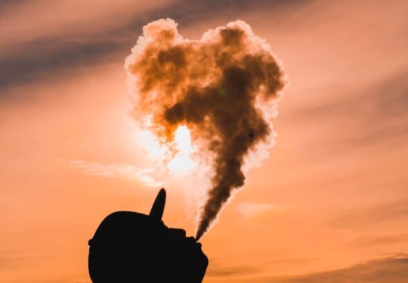 silhouette of man vaping during sunset