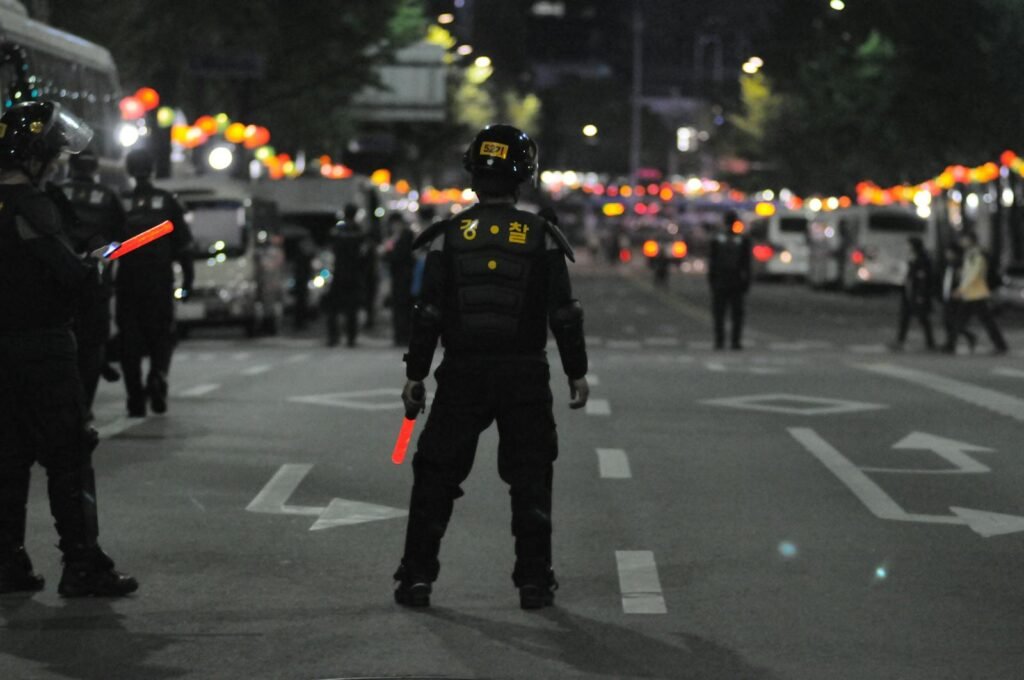 Senators Question Safety at Olympics & World Cup Amid LA Protests, Drone Threats 1 Police officers maintaining order during a night street patrol, ensuring public safety.