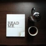 flat-lay photo of Read Me. book beside cup and silver mug on table. Press Release, guest post, sponsored posts, classified listing, ad, space, newsletter, press release, search page, forum, press release,