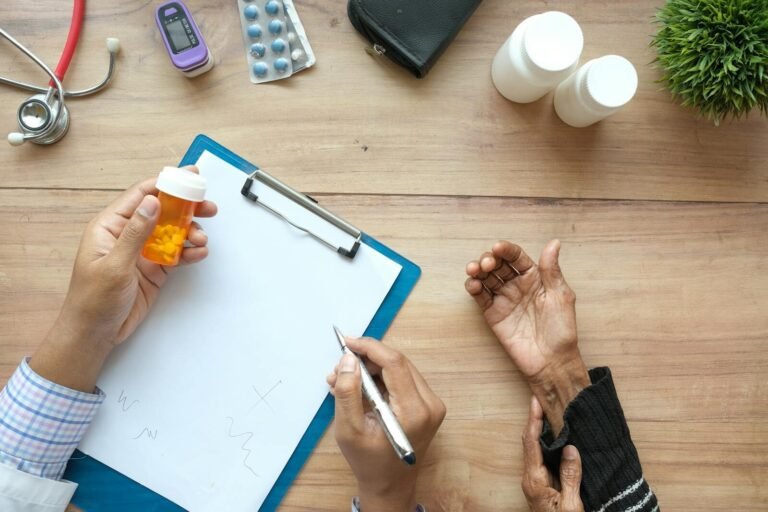 A doctor holds a pill bottle while consulting with an elderly patient. A stethoscope and prescriptions are visible. medicaid, medicare, health