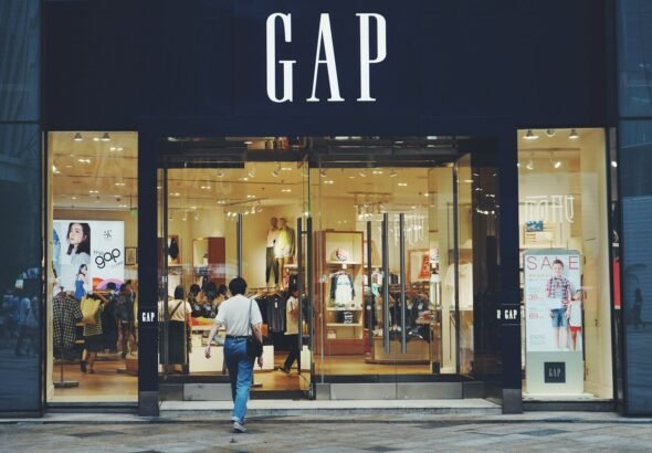 person in white shirt and blue jeans walking inside GAP store, gap