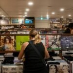 People browse vinyl records in a record store. charli xcx