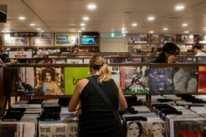 People browse vinyl records in a record store. charli xcx