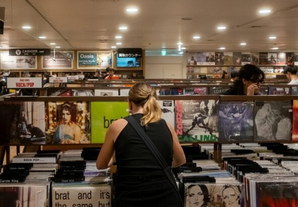 People browse vinyl records in a record store. charli xcx