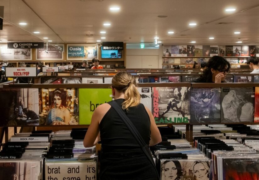 People browse vinyl records in a record store. charli xcx
