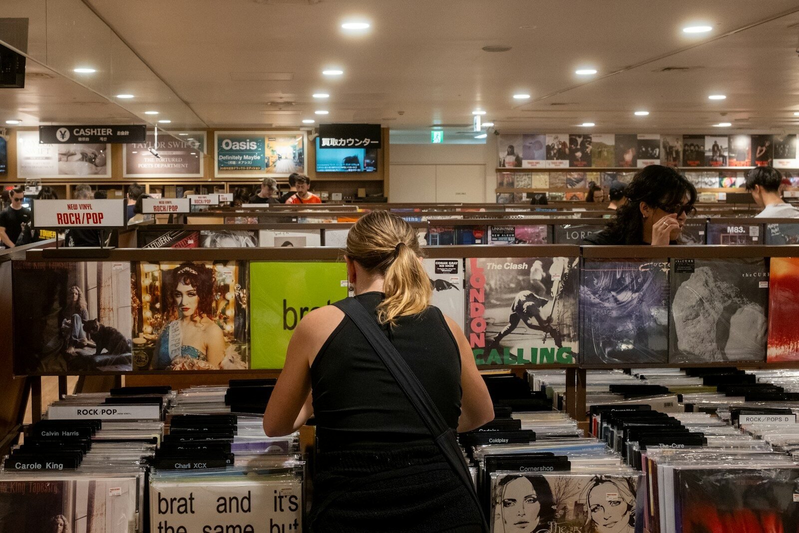 The Disorienting Glow of Superstardom: Charli xcx Turns the Camera on Herself in ‘The Moment’ 1 People browse vinyl records in a record store. charli xcx