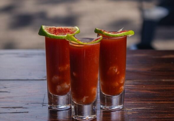 Three shot glasses filled with a bloody drink, Bloody Mary