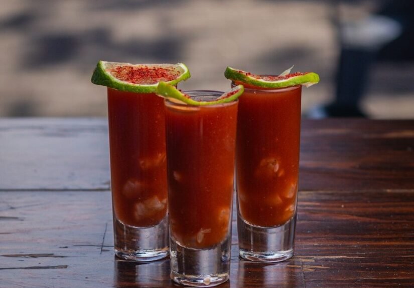Three shot glasses filled with a bloody drink, Bloody Mary