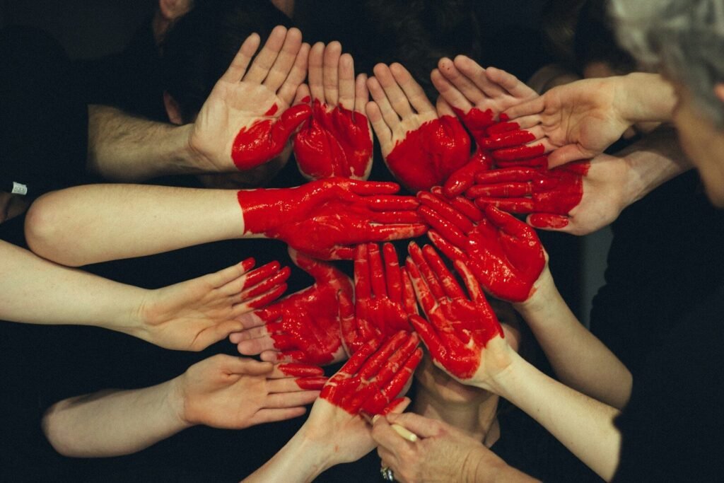 Support Independent Writing! 2 hands formed together with red heart paint