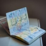 An open passport with numerous ink stamps on the pages on a table, travel, visa