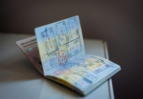 Five Charged in Alleged H-2A Visa Fraud and Alien Smuggling Ring That Seized Workers’ Passports, Demanded Kickbacks 10 An open passport with numerous ink stamps on the pages on a table, travel, visa