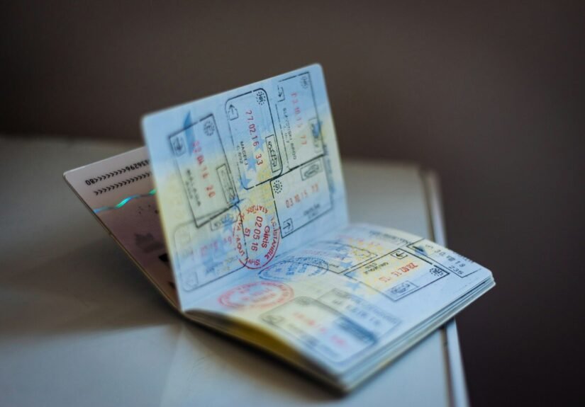 Five Charged in Alleged H-2A Visa Fraud and Alien Smuggling Ring That Seized Workers’ Passports, Demanded Kickbacks 31 An open passport with numerous ink stamps on the pages on a table, travel, visa